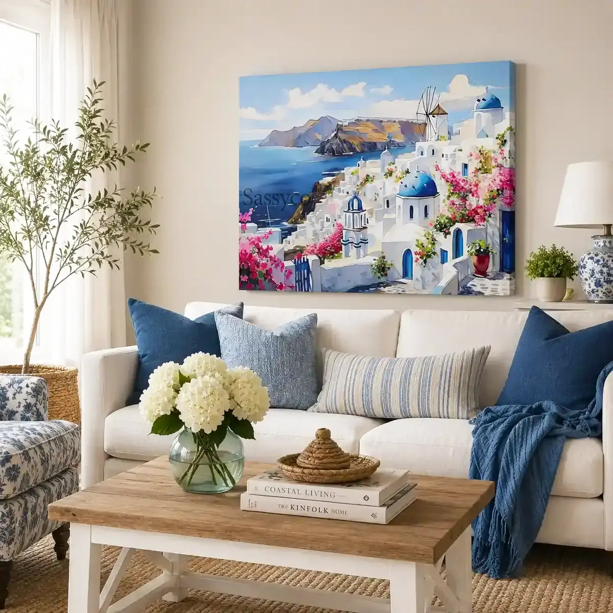 Santorini Greece Oia village cityscape with whitewashed homes, blue-domed churches, a windmill and bougainvillea over the Aegean Sea painting, styled in a living room - Greece island travel wall art, Mediterranean coastal canvas wall art, Santorini poster artwork print for living room, bedroom and home office wall decor
