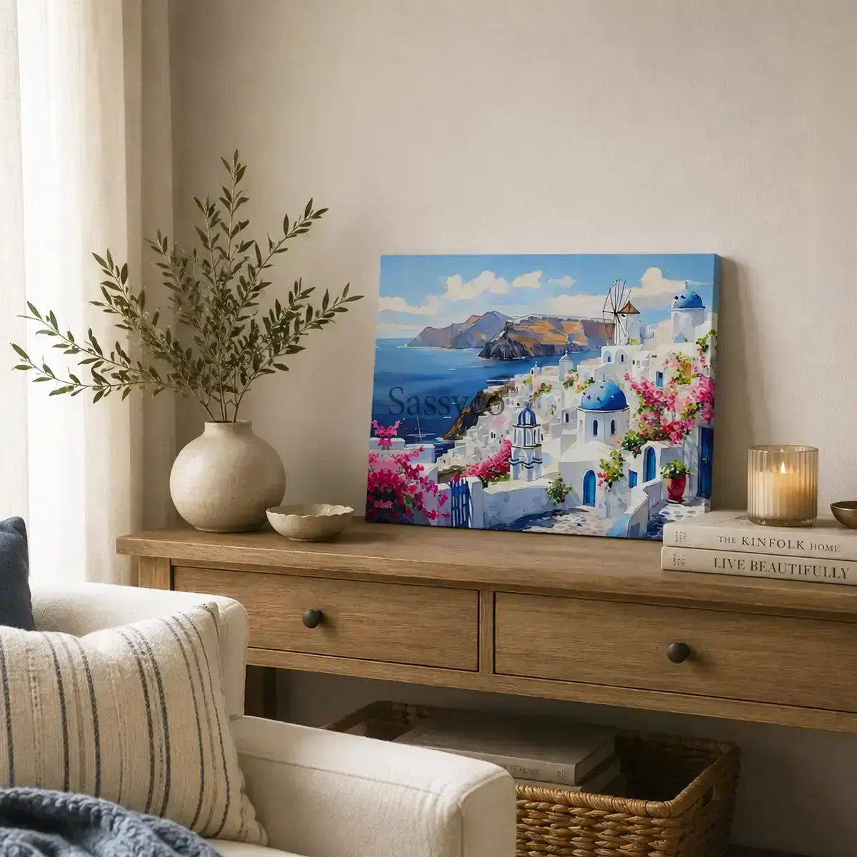 Santorini Greece Oia village cityscape with whitewashed homes, blue-domed churches, a windmill and bougainvillea over the Aegean Sea painting, styled in a living room - Greece island travel wall art, Mediterranean coastal canvas wall art, Santorini poster artwork print for living room, bedroom and home office wall decor